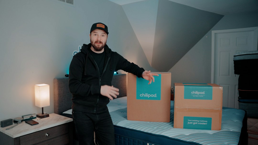 Man standing next to two delivery boxes on a bed
