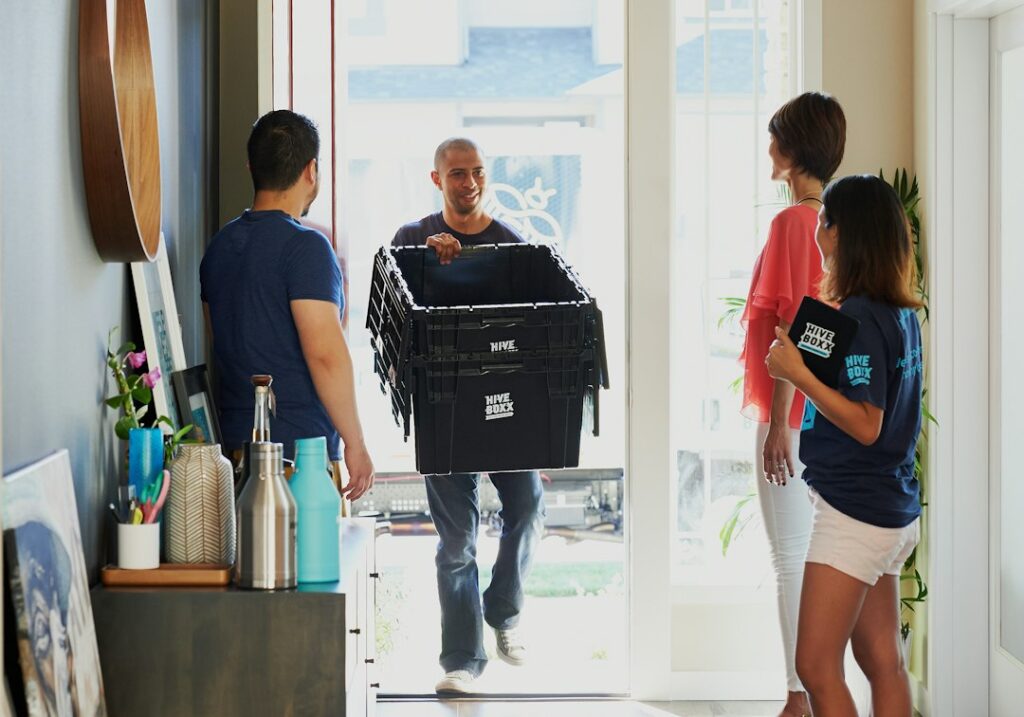 man in black crew neck t-shirt holding black plastic bag