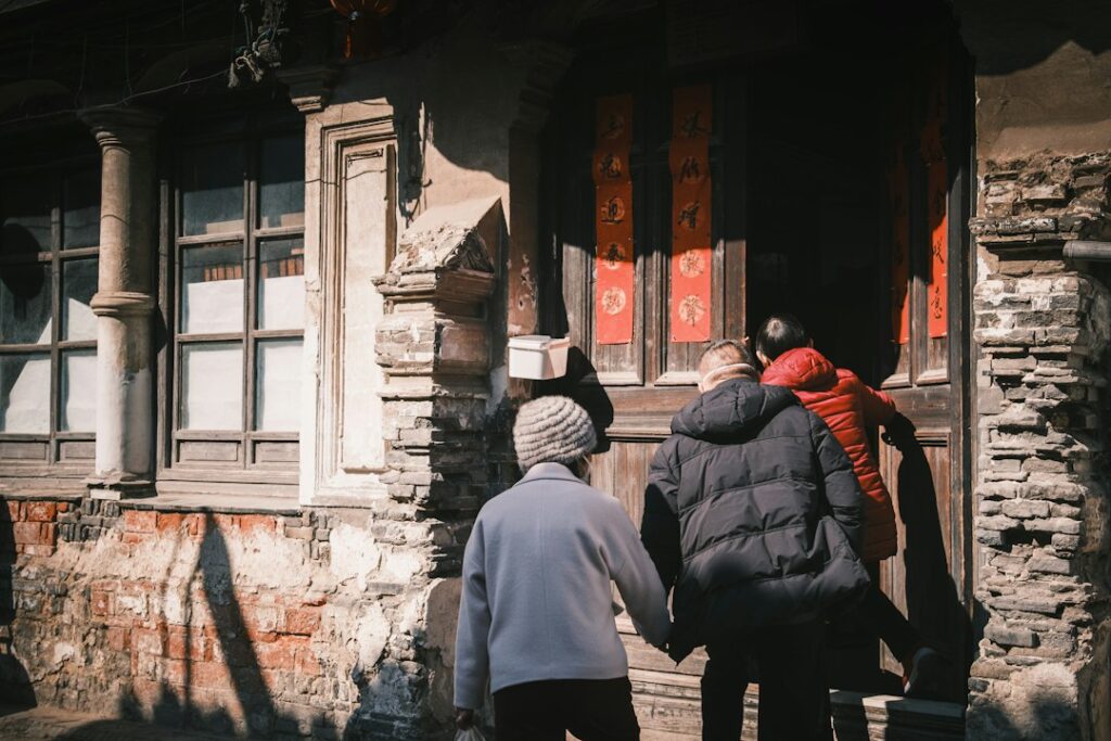 People entering an old building with ornate doors