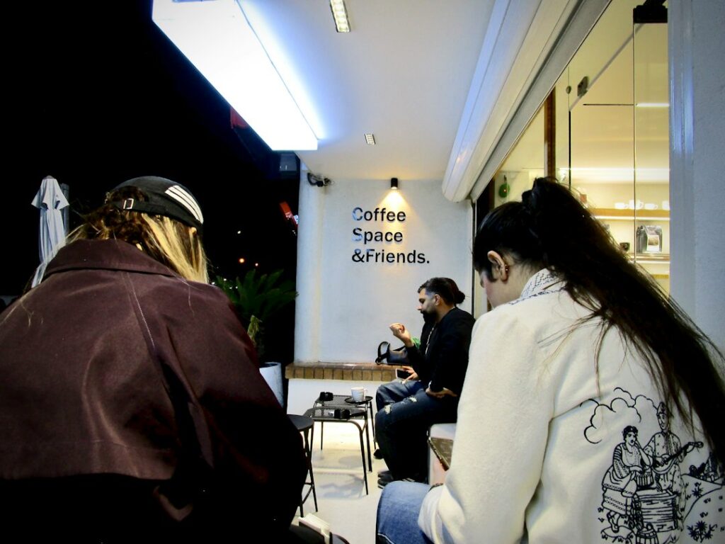 People gathered outside a coffee shop at night