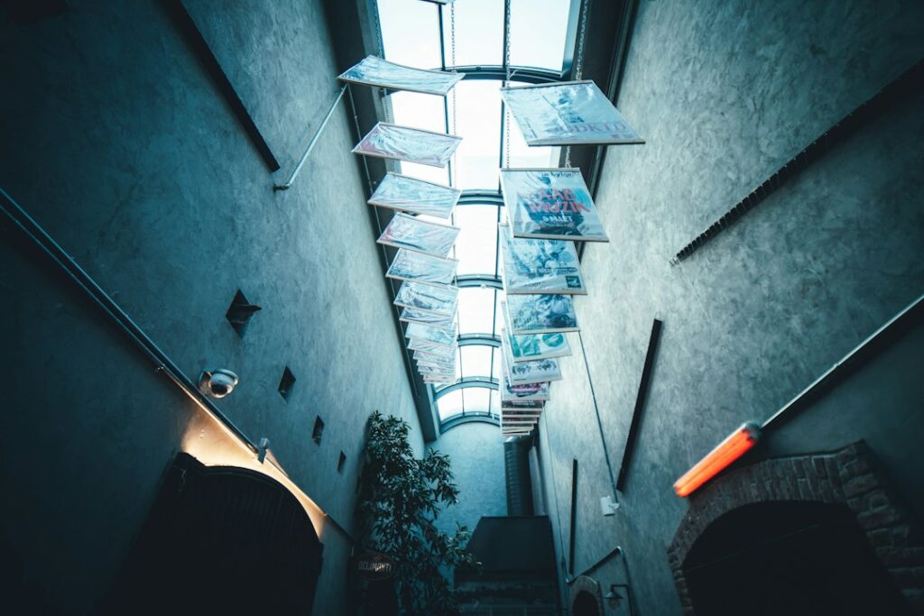 plants besides white building wall with tarpaulins hanging on ceiling
