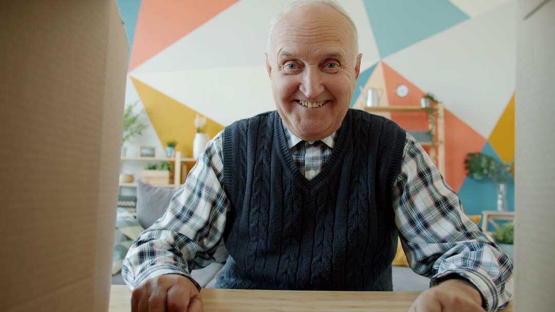 Smiling elderly man looking into a cardboard box