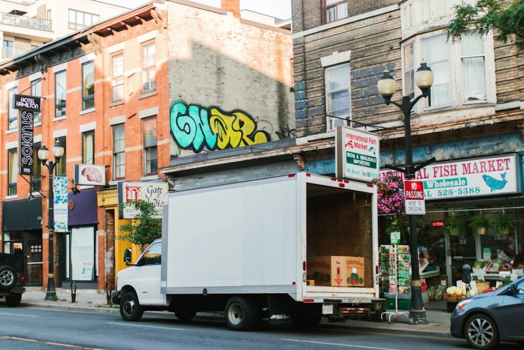 White truck parked on a city street with shops